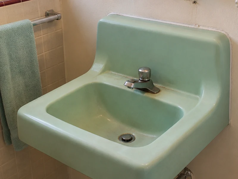 Worn mint-green vintage porcelain sink in a Mission San Jose home before reglazing, Fremont
